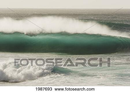 Stock Image - USA, Hawaii, Oahu, North Shore, Crashing backlit wave; Pipeline. Fotosearch