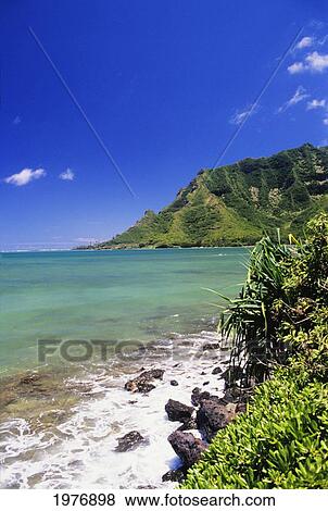 Stock Photo - USA, Hawaii, Oahu, Turquoise Blue Shoreline With Lush Green Mountains In Distance; Kahana Bay. Fotosearch