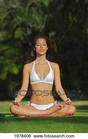 Stock Photograph - USA, Hawaii, Oahu, Woman doing yoga on grass At Kapiolani Park; Waikiki. Fotosearch