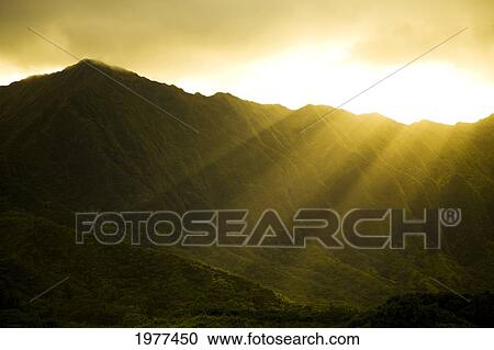 Stock Image - USA, Hawaii, Sunlight over Ko'olau Mountains and Kualoa Ranch; Oahu. Fotosearch