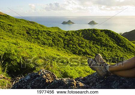 Stock Photograph - USA, Hawaii, View of hicking boots and mountains with view of Mokulua Islands; Lanikai. Fotosearch