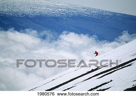 Stock Photograph - USA, Hawaii, Woman skiing downhill at Mauna Kea; Big Island. Fotosearch