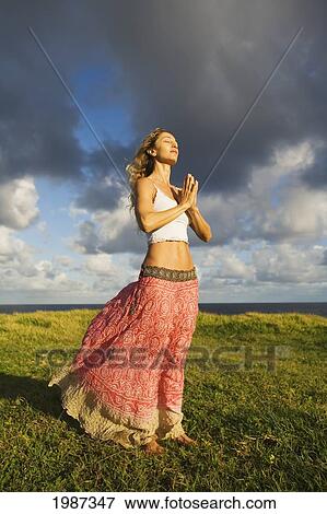 USA, Hawaii, Young woman doing yoga on grassy hill near Pacific Ocean; Maui View Large Photo Image Stock Photo - USA, Hawaii, Young woman doing yoga on grassy hill near Pacific Ocean; Maui. Fotosearch