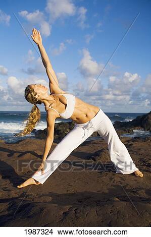 Picture - USA, Hawaii, Young woman doing yoga near Pacific Ocean; Maui. Fotosearch
