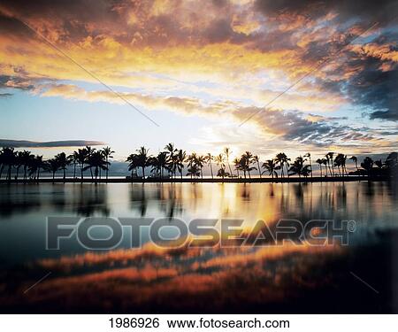 Stock Photograph - USA, Hawaiian Islands, Big Island, South Kohala, Dramatic and colorful sunset sky; Anaeho'omalu Bay. Fotosearch