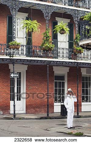 USA, Louisiana, French Quarter; New Orleans, Man in white suit standing in front of traditional housel View Large Photo Image Stock Photo - USA, Louisiana, French Quarter; New Orleans, Man in white suit standing in front of traditional housel. Fotosearch