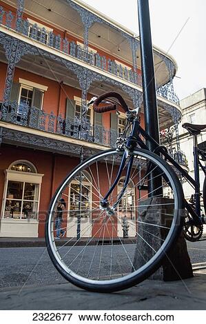 Stock Photo - USA, Louisiana, French Quarter; New Orleans, Bicycle chained to lamp post. Fotosearch