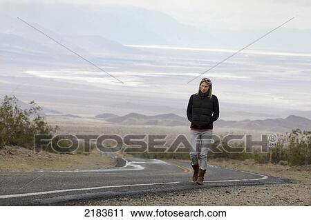 Usa, Nevada Border, California, Route 374; Death Valley National Park, Highway 374, Young Woman Walking On Deserted Road In Desert View Large Photo Image Stock Image - Usa, Nevada Border, California, Route 374; Death Valley National Park, Highway 374, Young Woman Walking On Deserted Road In Desert. Fotosearch