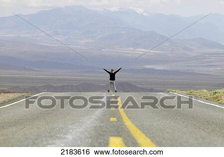 Usa, Nevada Border, California, Route 374; Death Valley National Park, Highway 374, Young Woman Standing On Deserted Road In Desert View Large Photo Image Stock Photograph - Usa, Nevada Border, California, Route 374; Death Valley National Park, Highway 374, Young Woman Standing On Deserted Road In Desert. Fotosearch
