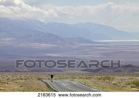 Usa, Nevada Border, California, Route 374; Death Valley National Park, Highway 374, Young Woman Standing On Deserted Road In Desert View Large Photo Image Stock Photography - Usa, Nevada Border, California, Route 374; Death Valley National Park, Highway 374, Young Woman Standing On Deserted Road In Desert. Fotosearch