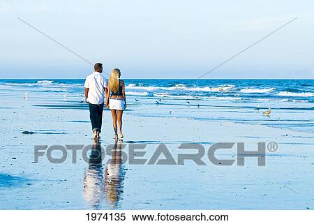 Stock Photography - Usa, New Jersey, Avalon, Caucasion Couple Walking Along Shoreline Holding Hands.. Fotosearch