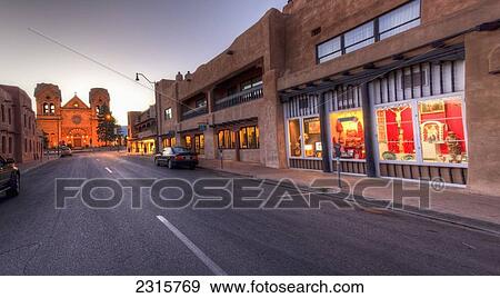 Stock Photo - USA, New Mexico, Santa Fe, East San Francisco Street looking toward St. Francis of Assisi Cathedral and La Fonda Hotel at dawn. Fotosearch