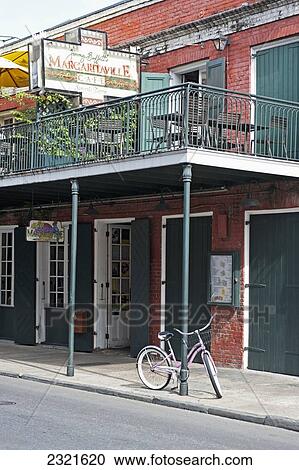 Stock Image - USA, New Orleans, Louisiana, Bicycle leaning on pole outside restaurant. Fotosearch