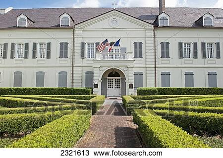 USA, New Orleans, Louisiana, White building with hedges lining paths and American flag View Large Photo Image Stock Image - USA, New Orleans, Louisiana, White building with hedges lining paths and American flag. Fotosearch