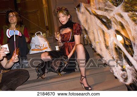 Stock Image - Usa, New York State, Adults In Halloween Costumes At Frontyard; New York City. Fotosearch