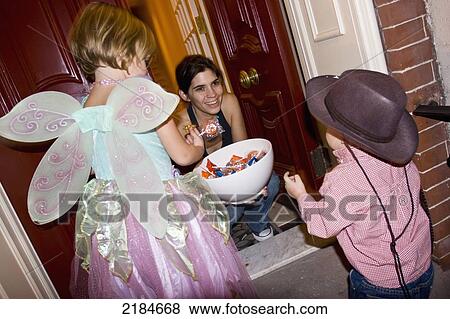 Stock Photo - Usa, New York State, Children In Halloween Costumes Receiving Sweets; New York City. Fotosearch