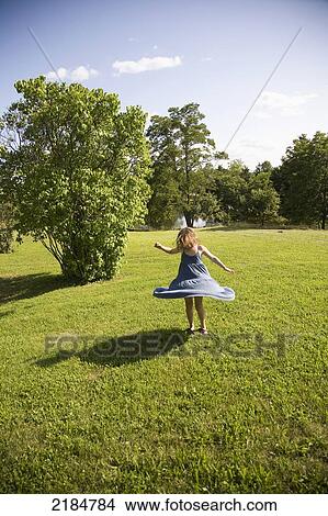 Picture - Usa, New York State, Girl Spinning On Green Grass; Hudson Valley. Fotosearch