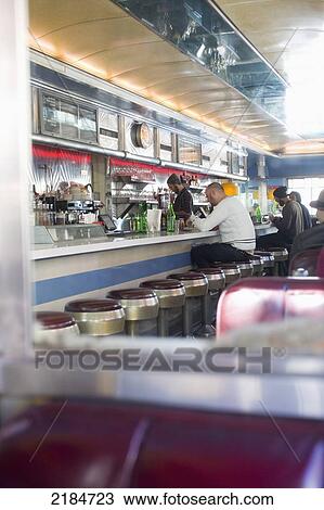 Stock Image - Usa, New York State, New York City, Brooklyn, Men Eating Cheeseburgers At Relish Diner; Williamsburg. Fotosearch