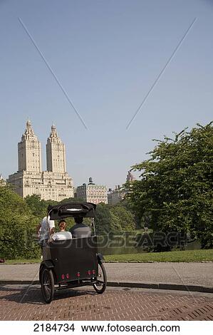 Usa, New York State, Tourists In Pedicab Overlooking Water In Central Park; New York City View Large Photo Image Picture - Usa, New York State, Tourists In Pedicab Overlooking Water In Central Park; New York City. Fotosearch