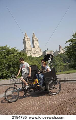 Stock Photography - Usa, New York State, Tourists In Pedicab Overlooking Water In Central Park; New York City. Fotosearch