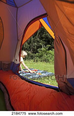 Stock Photography - Usa, New York State, Woman Setting Up Picnic Seen From Tent; Hudson Valley. Fotosearch