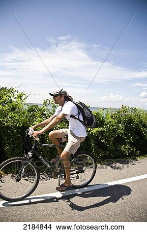 Picture - Usa, Rhode Island, Young Man Bicycling Along Ocean Avenue; Newport. Fotosearch