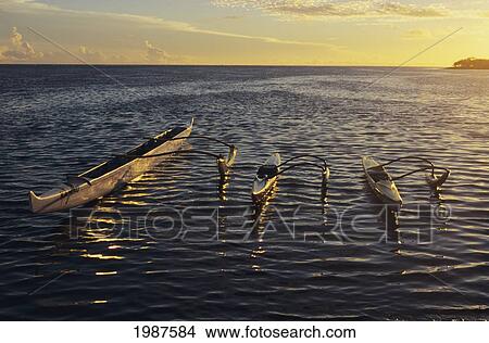 USA, Three outrigger canoes floating on rippling ocean water at sunset; Hawaii View Large Photo Image Picture - USA, Three outrigger canoes floating on rippling ocean water at sunset; Hawaii. Fotosearch
