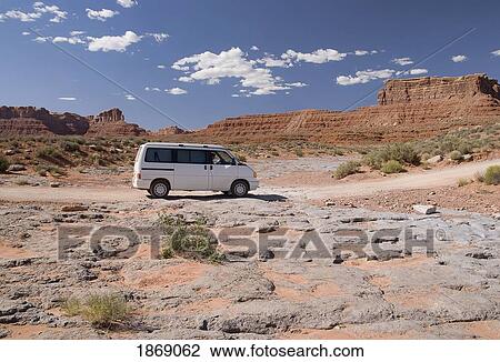 Stock Image - Utah, United States Of America; A Mini-Van Driving Through The Valley Of The Gods. Fotosearch