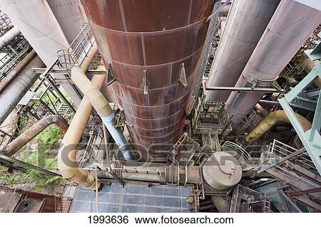 Stock Photograph - Vegetation growing amongst the rusting machinery of Volklinger Hutte (Volklingen Ironworks), Volklingen, Germany. Fotosearch