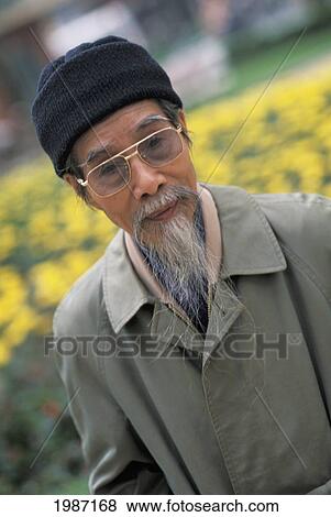 Vietnam, Portrait of man with beard and yellow flowers in background; Hanoi View Large Photo Image Stock Photo - Vietnam, Portrait of man with beard and yellow flowers in background; Hanoi. Fotosearch