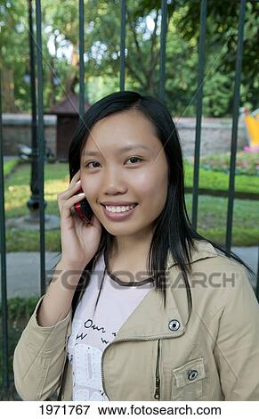 Vietnam, Saigon, Ho Chi Minh, Portrait Of A Young Vietnamese Woman Talking On Her Cellular Phone. View Large Photo Image Stock Photo - Vietnam, Saigon, Ho Chi Minh, Portrait Of A Young Vietnamese Woman Talking On Her Cellular Phone.. Fotosearch