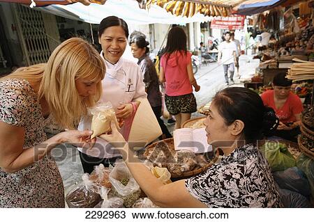 Stock Image - Vietnam, Tourist with cook at market Metropole Hotel Cookery School; Hanoi. Fotosearch
