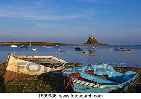 Stock Photograph - View Across Water And Boats To Lindisfarne Castle On Holy Island.. Fotosearch