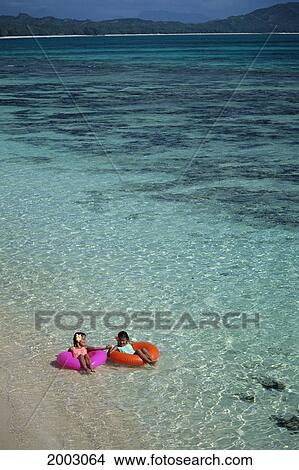 View From Above Girls Floating In Colorful Inner Tubes, Shallow Turquoise Ocean View Large Photo Image Picture - View From Above Girls Floating In Colorful Inner Tubes, Shallow Turquoise Ocean. Fotosearch