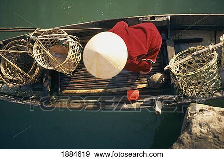 Stock Photo - View From Above Of Vietnamese Woman In Conical Hat In A Boat. Fotosearch