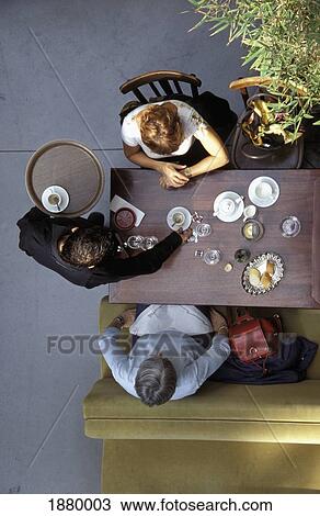 Stock Image - View From Above Of Waiter Clearing Table At Cafe. Fotosearch