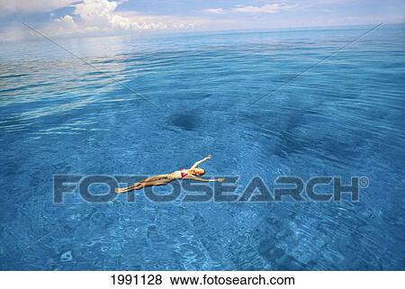 Stock Photo - View From Above Woman In Bikini Floating In Beautiful Blue Ocean. Fotosearch