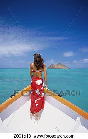 Stock Image - View From Behind Young Woman Standing On Bow Of Boat Calm Turquoise Ocean Island Background D1106. Fotosearch