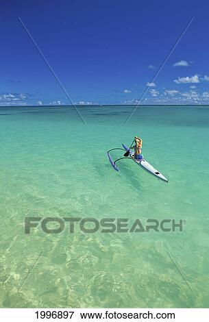 Stock Photo - View From Distance Behind Woman In Single Outrigger Canoe, Calm Water, Blue Skies. Fotosearch
