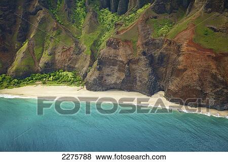 Stock Photo - View of a beach along the coast of an hawaiian island; Na Pali coast of Kauai, Hawaii, United States of America. Fotosearch