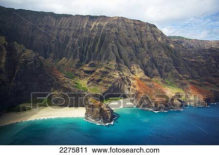 Stock Image - View of a beach along the rugged coast of an hawaiian island; Na Pali coast of Kauai, Hawaii, United States of America. Fotosearch