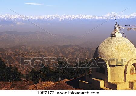Stock Image - View of central himalayan mountain range from Mount Phulchowski and small white stupa in foreground; Nepal. Fotosearch