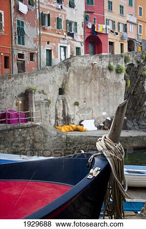Stock Photo - View of colourful buildings and boats in a river in Riomaggiore in Cinque Terra; Riomaggiore, Liguria, Italy. Fotosearch