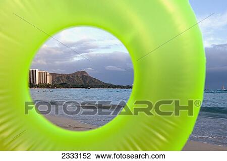Stock Image - View of Diamond Head seen through a green inflatable tube; Waikiki, Oahu, Hawaii, United States of America. Fotosearch