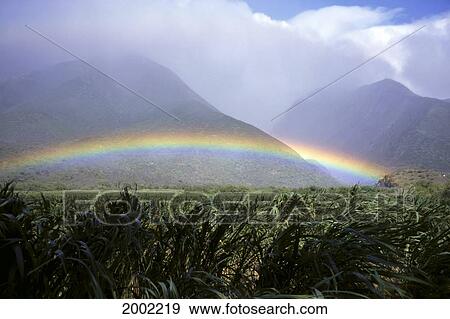 View Of Low Rainbow At Base Of Mountains, Clouds, Blue Sky, Field View Large Photo Image Stock Photo - View Of Low Rainbow At Base Of Mountains, Clouds, Blue Sky, Field. Fotosearch