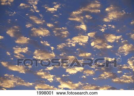 Stock Image - View Of Many Tiny Clouds In Blue Sky Reflecting Sunlight. Fotosearch