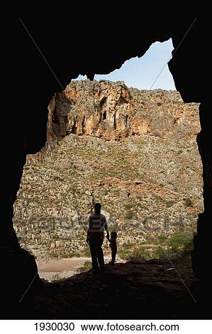 Stock Image - View Of Parent And Child From Cave; Crete, Greece. Fotosearch