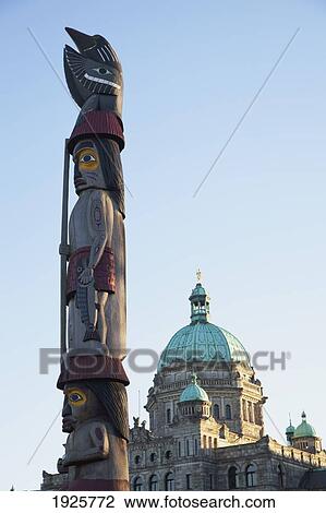 Stock Image - View Of Parliament Buildings & Totem Pole; Victoria, British Columbia, Canada. Fotosearch