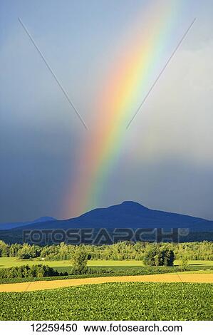 Stock Image - View of rainbow and Mont Pinacle from Saint-Armand; Eastern Townships, Quebec, Canada. Fotosearch