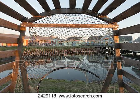 Stock Photo - View of Spinnakers Landing through a lobster trap; Summerside, Prince Edward Island, Canada. Fotosearch